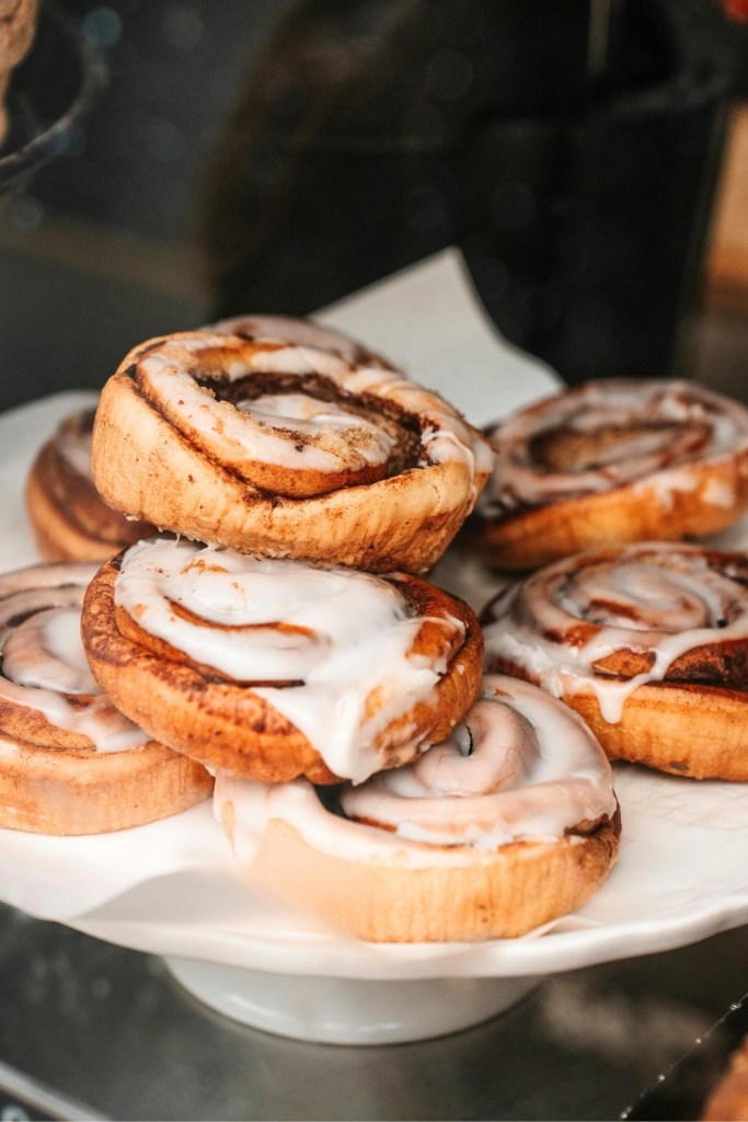Zimtschnecken aus Hefeteig, frisch aus dem Ofen. Weihnachten, Zuckerguss Glasur. Schritt-für-Schritt Rezept Anleitung